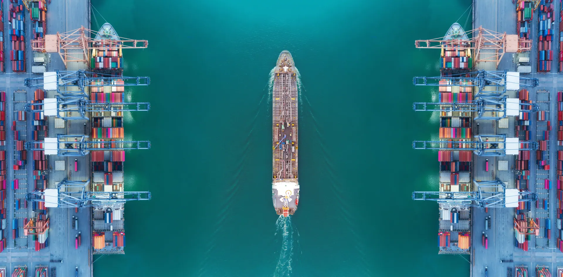 Aerial view of a vessel moving through an active container port