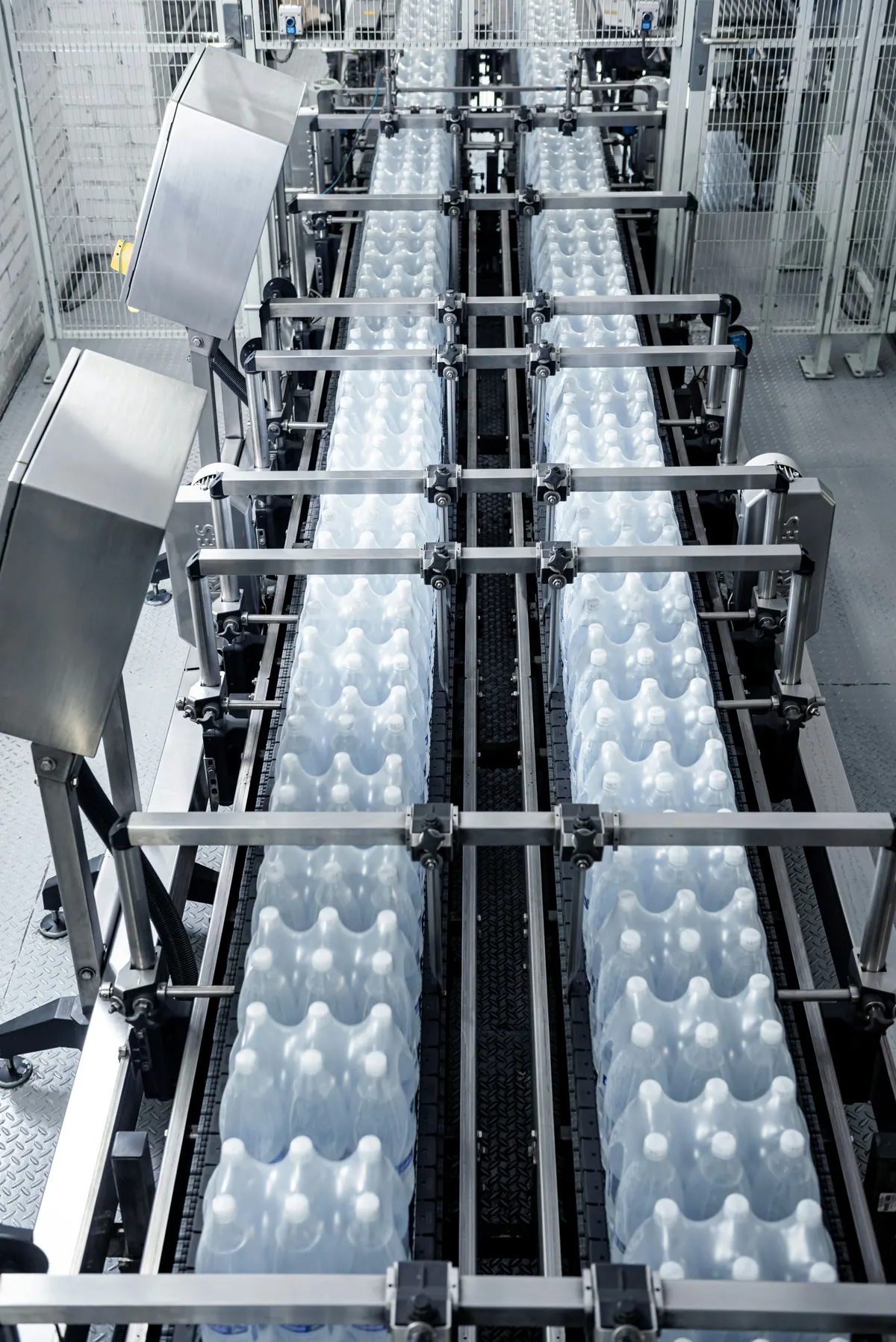 Packaged water bottles moving through production-line equipment